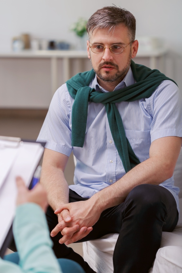A man engaged quietly in a healing conversation in a Worthing listening session